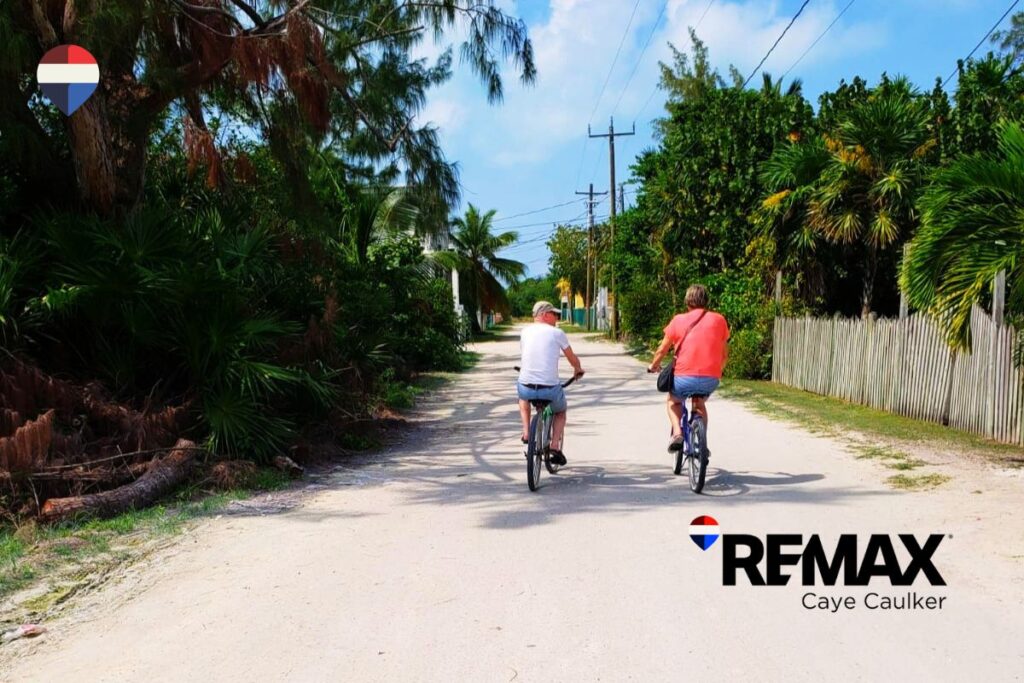 People on their bicycles on a sandy street on Caye Caulker